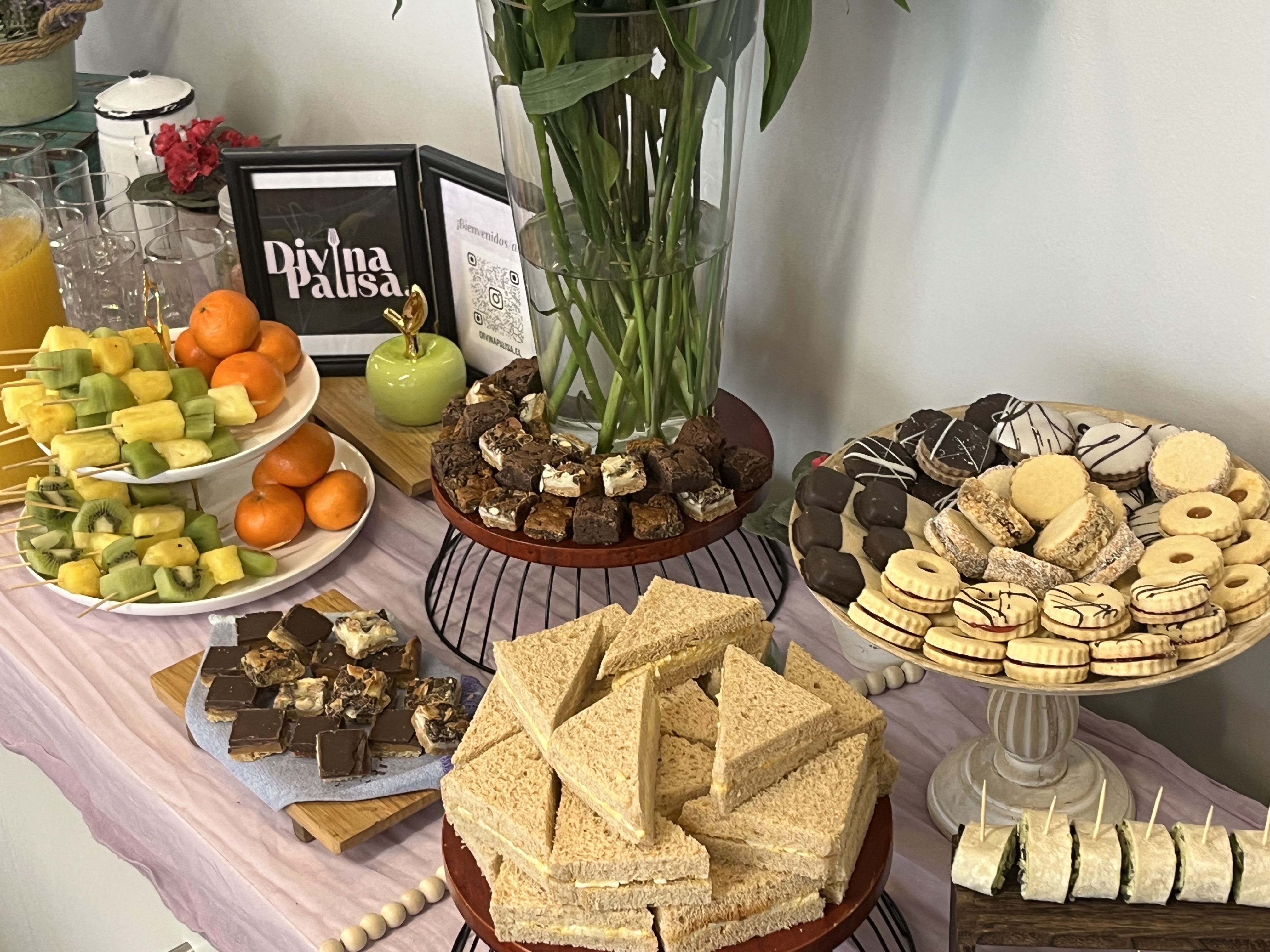 Mesa de coffee break con frutas, pastelería y sándwiches