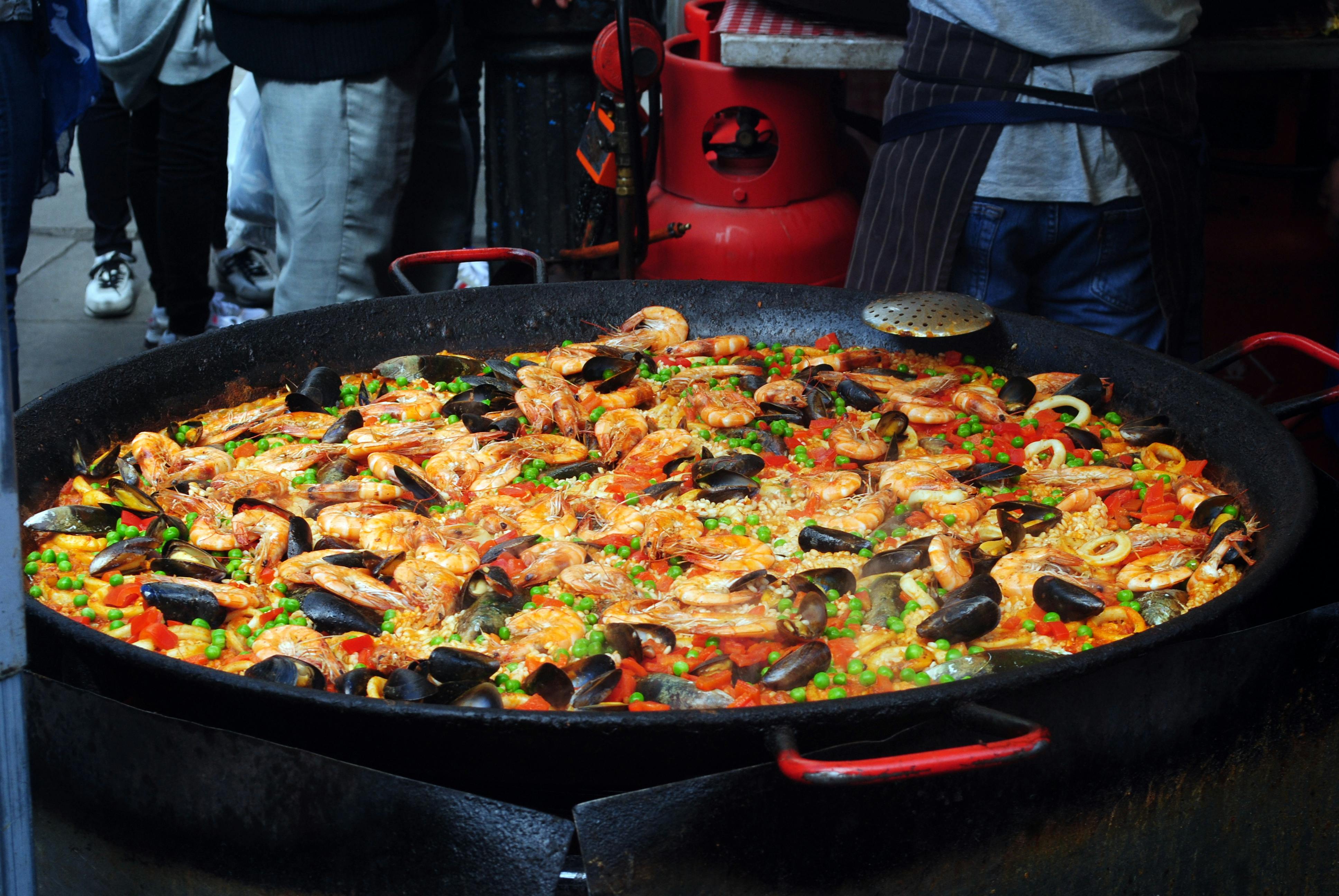 Chef cocinando una gran paella española en un evento
